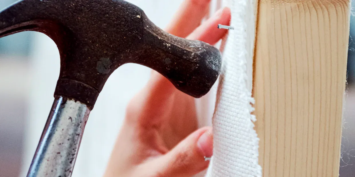 A claw hammer resting on a wooden workbench