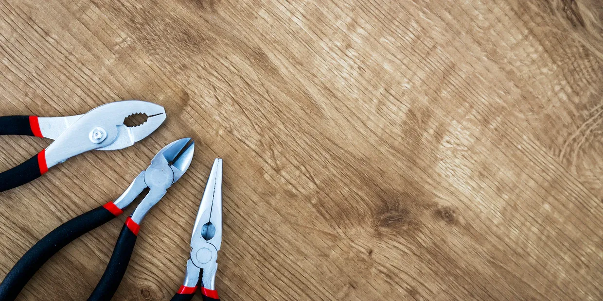 A set of pliers laid out on a workbench